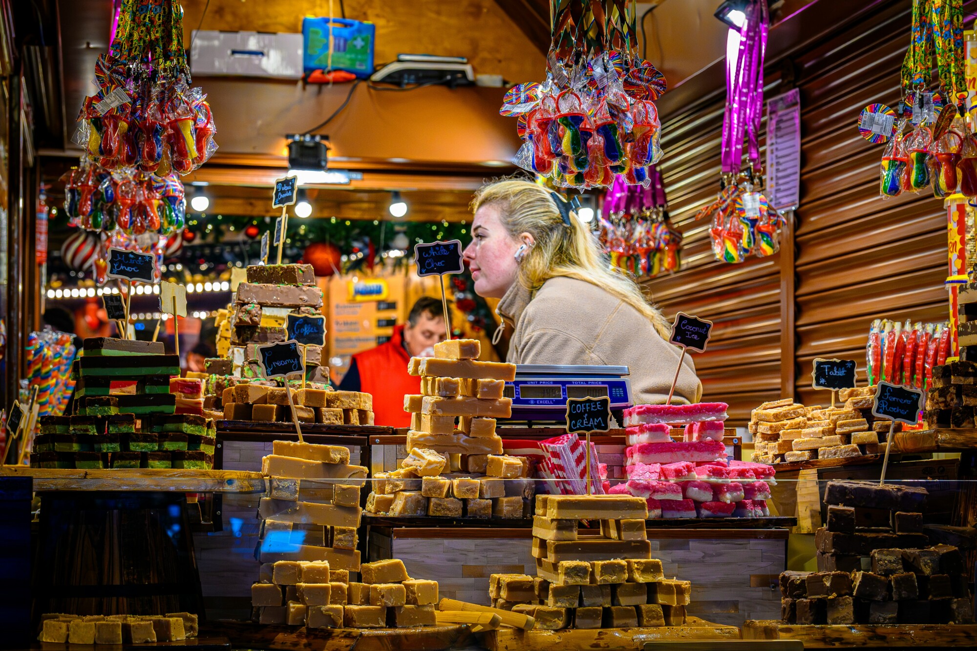A vendor in a booth at a holiday market
