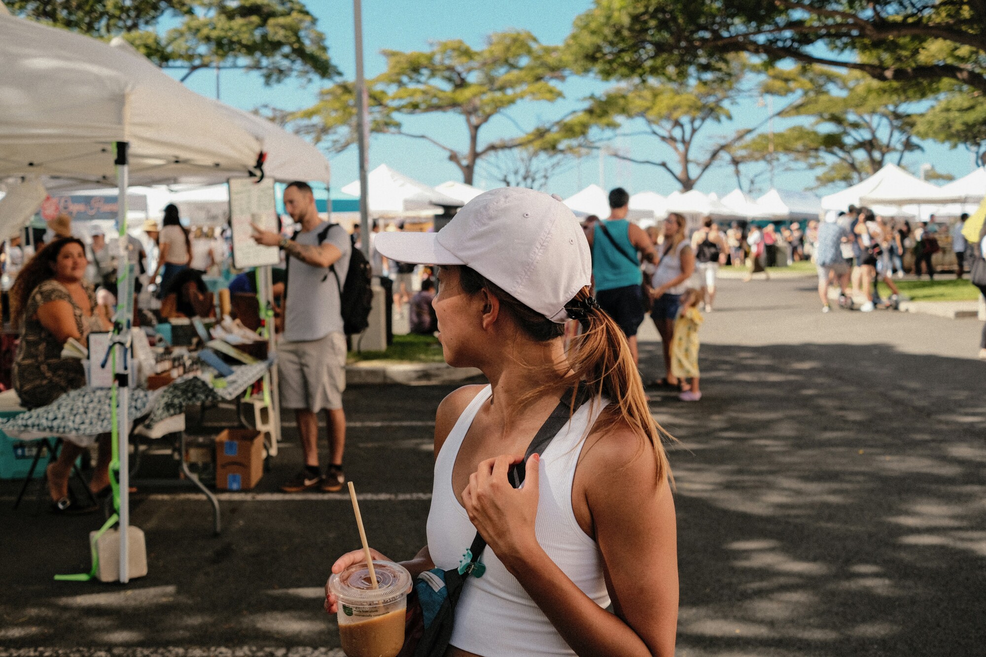 A woman holding a beverage at an outdoor event