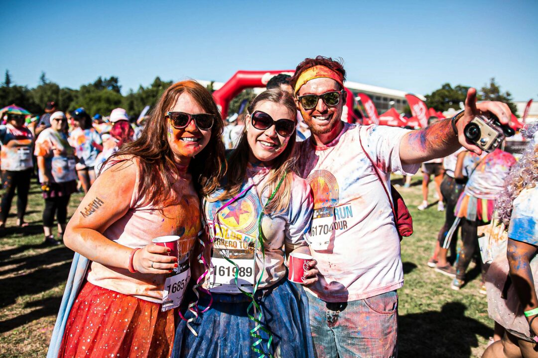 Three friends standing together after a run run event.